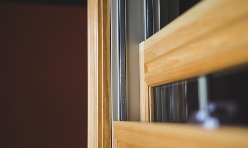 A close up of a double hung window with a wooden frame.